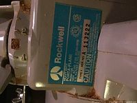 Close-up of blue Rockwell label with model and serial number showing rust spots