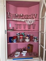 Photo showing shelves filled with assorted stemware, coffee mugs, small glass items, and salt and pepper shakers.