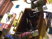 Photo showing tile cutter handle, Ryobi angle grinder, and various tools in wooden box