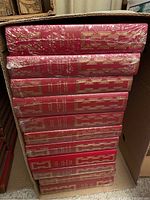Cardboard box opened, showing stack of red leather-bound Agatha Christie novels upright