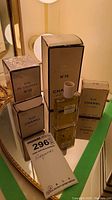 Group shot of four Chanel fragrance boxes and bottles on mirrored surface
