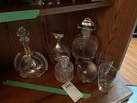 Group view of all decanters, glasses and spear on shelf