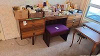 Full front view of wood dresser with bench and assorted boxes on top