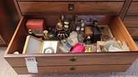 Top view of wooden drawer with assortment of boxed and loose perfume bottles