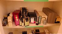 Wide view of upper and lower shelves showing assortment of boxed fragrances