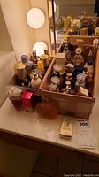 Overall view of cardboard box containing assortment of perfume bottles on vanity