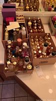 Four cardboard boxes on countertop containing a mix of glass and plastic fragrance bottles.