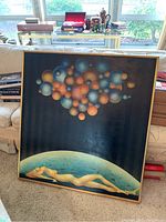 Full view of square painting leaning against sofa in living space