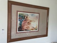 Framed artwork featuring a watercolor-style painting with a wooden frame and beige offset matte. Corner scuff visible on frame.