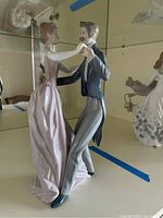 Side view of the Lladro dancing couple porcelain figurine showing details of woman's dress and man's attire.