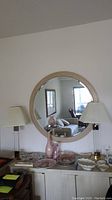 Framed round wall mirror showing full front view including the stepped frame design and reflections of room.