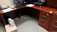 Full view of the L-shaped office desk showing top surface, drawers on the right side, and open leg area beneath the desk.
