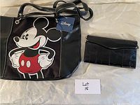 Image of Disney tote bag with Mickey Mouse graphic and black eel skin wallet on a light surface.