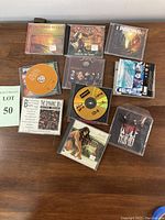 Full lot of 10 music CDs arranged on wood surface