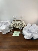 Full set of wine and champagne glasses displayed, some wrapped in protective paper, showing quantity and general style.