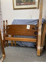 Antique maple rope bed frame with turned posts and wooden headboard and footboard.