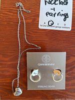 Gianni Bernini sterling silver textured hoop earrings on display card alongside Italian 925 necklace with heart pendant on wooden surface.