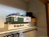 Various shoeboxes stacked on a shelf including brands Elyse and others
