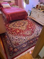 Full view of red wool rug under bed and between furniture