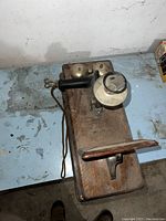 Top-down angled view of the oak telephone showing mouthpiece, receiver, and brass bells.