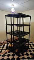 Two black plastic shelving units next to each other showing all five shelf levels