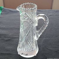 Side view of the crystal pitcher vase showing the handle, spout, and intricate cut glass pattern.