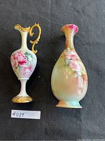 Two painted China vases on a dark surface, showing both vases side by side.