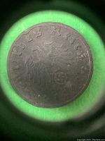 Close-up of obverse side showing eagle holding swastika with text 'Deutsches Reich 1942',' taken to verify authenticity and details on the coin.