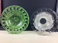 Two large glass bowls, one green with pierced circle edge and floral etching, the other clear with scalloped edge and floral design.