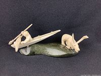 Angled front view showing hunter in kayak on green base and caribou figure