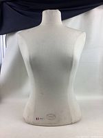 Back view of female torso mannequin, showing fabric texture and minor imperfections.