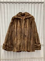 Full front view of vintage beaver fur coat with collar and cuffs visible, hung on hanger.