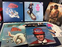 Photo of seven Laserdisc movies laid out showing cover artwork including Airplane II: The Sequel, The Naked Gun, The Firm, and Toys.