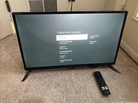 Front view of the 24-inch Insignia TV showing language selection screen.