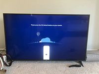 LG 55" TV powered on showing setup screen asking to press OK button on remote.