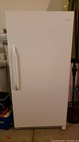 Front exterior view of the white Frigidaire upright freezer showing the door closed and handle on left side.