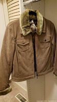 Tan corduroy jacket hanging, showing faux fur collar and front chest pockets