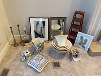 Full set of living room decor items arranged on carpet: prints, lampshades, lamps, pillows, mirror, shelf, decorative dish, tissue cover, trash can