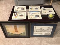 Five certificates of authenticity and framed pencil sketch and photo are displayed on a coffee table.