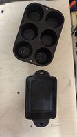 Top view of cast iron mini muffin pan with six round cups and one mini loaf pan below it.