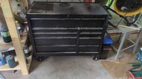 Front view of black steel Mastercraft Maximum rolling tool chest showing eight drawers, lid on top, mounted on casters
