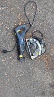Photo showing a Mastercraft circular saw and a reciprocating saw laid on pavement, both with power cords visible.