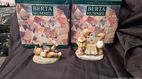 Pals #BH4 and Wish Comes True #BH17 figurines in front of original boxes with village illustration and 'Berta Hummel' branding