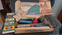 Wide view showing box interior with train cars, track, catalogs and transformer