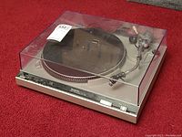 Overall view of turntable with dust cover down on red carpet