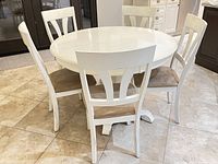 Full view of white round table with eight matching chairs