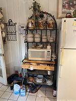 Full view showing entire baker's rack with items on shelves and surrounding area