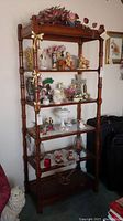 Front view of the 5-tier wooden display shelf with various decorative items on shelves, showing the full height and structure