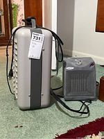 Front and side view of Titan heater showing vented design, handle, and attached power cord alongside smaller Patton heater with control knob and indicator light on top.