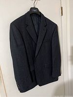 Dark gray men's suit jacket hanging on a Chaps branded hanger, showing front and shoulders.